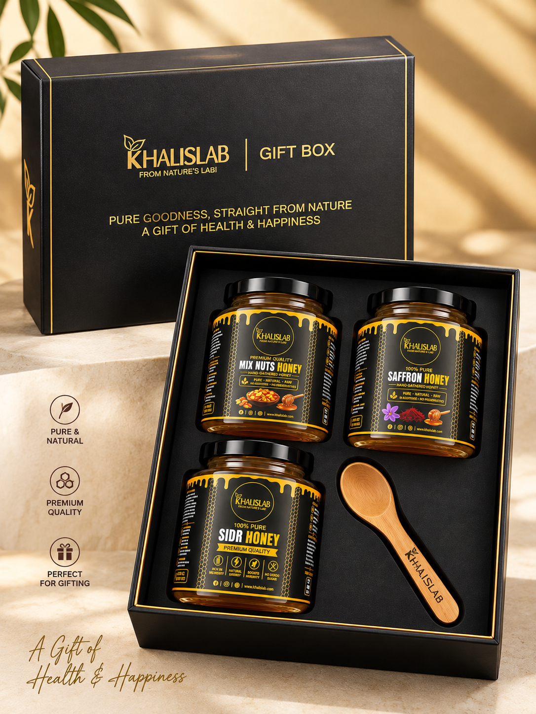 Khalislab gift box set containing three jars of honey and a wooden spoon, displayed in an open black box with the matching gift box lid behind it on a beige surface.