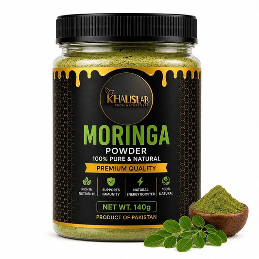 A jar of Khalslab Moringa Powder on a white background, next to a small wooden bowl filled with green powder and fresh green moringa leaves.